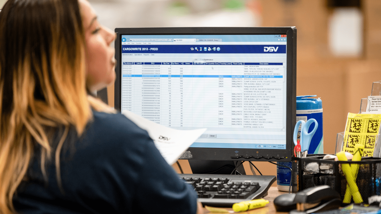 DSV-medarbeider sitter foran datamaskin og håndterer dokumentasjon